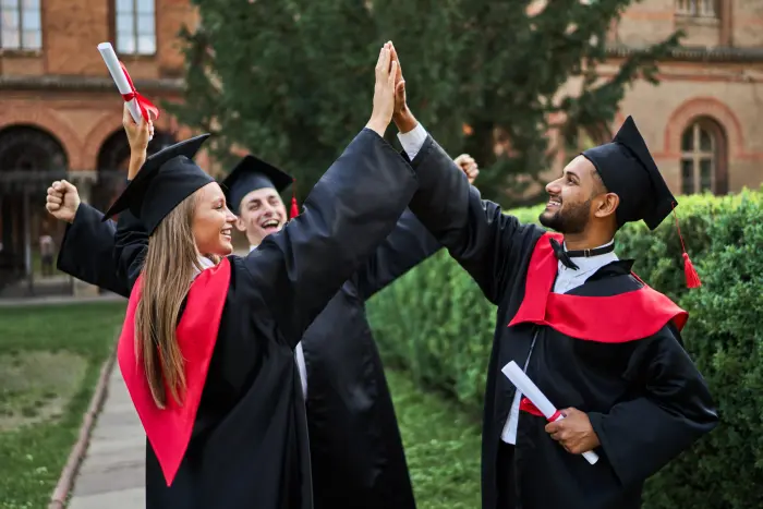 Pakistani graduates celebrating together on university campus after completing their BSc Hons Computing degree