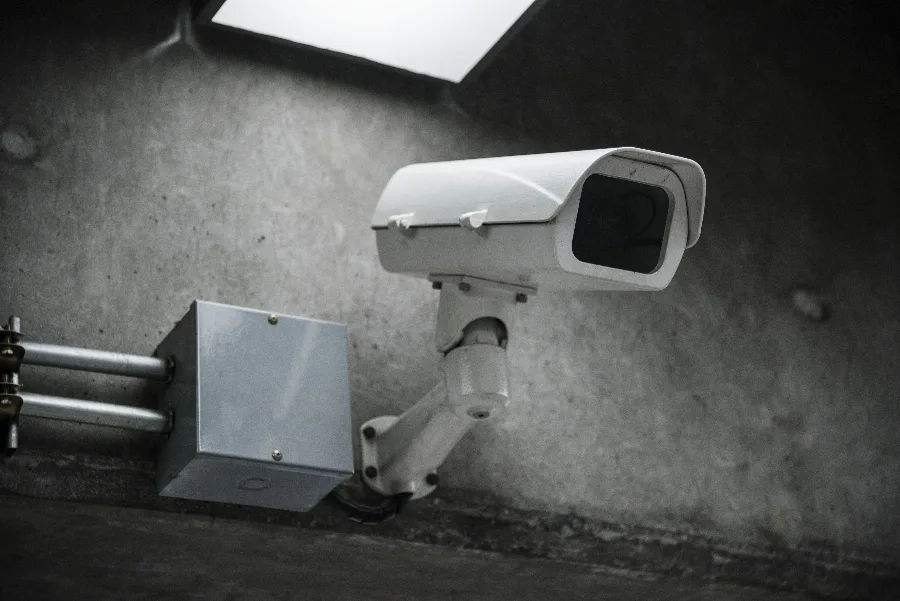 Close-up of a CCTV security camera mounted on a campus building wall