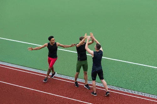 Students standing together on an outdoor running track at the campus athletics facility